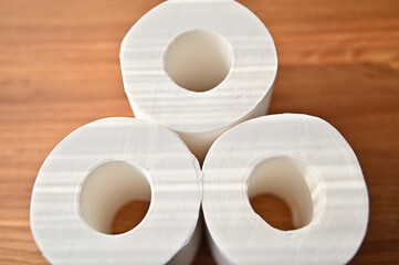 There are three rolls of toilet paper on the table.