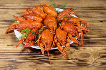 Boiled crayfish in plate on wooden table