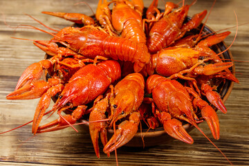 Boiled crayfish in plate on wooden table
