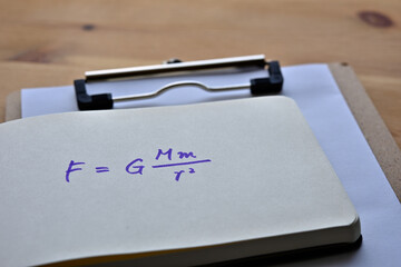 Close up of the notes with the formula for the law of universal gravitation.