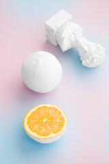 citrus orange painted white with small bust on pale pink and baby blue background 