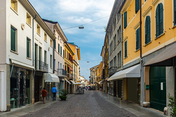 View of typical street with walking people in historical center of Pordenone in sunny autumn day, Italy
