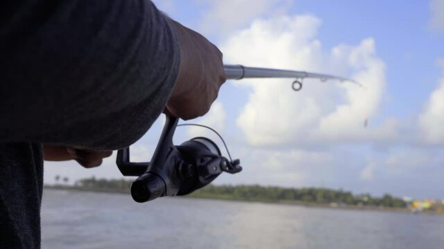 slow mo fishing reel and rod closeup blue sky cloudes beach uhd