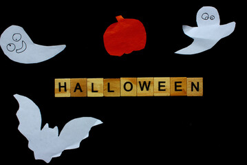 Word Halloween. Wooden blocks with an inscription on black background decorated with bats, pumpkin...