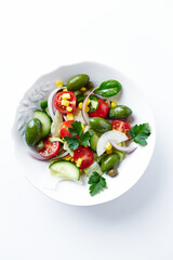 Healthy Salad with Feta Cheese, Green Olives, Baby Spinach, Cucumber, Cherry Tomatoes and Capers. Bright background. Top view. Close up. 