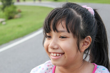 asian young girl with pink bow smiling