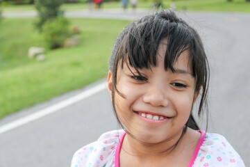 asian young girl with pink bow smiling