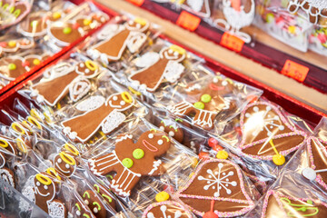 Fototapeta na wymiar Ginger cookies of different shapes. Gingerbread man and christmas mood in blurred background. Christmas market in old town European small city.