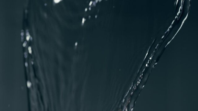 Crystalline Fluids Rapidly Pour Down With Splashing Microbubbles In A Blurry Background. - Macro Shot