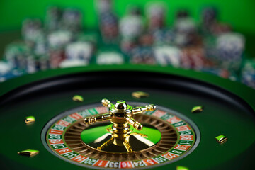 Casino theme, close up of roulette, red and black numbers. Stack of chips in the background.
