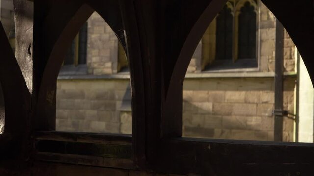 View of English church through wooden lych gate panning shot