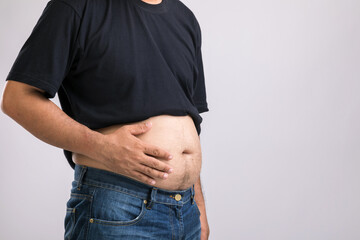 Medical check up concept : Fat people showing his big belly. Used for liver problem or Obesity concept. Studio shot on grey