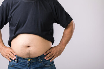 Medical check up concept : Fat people showing his big belly. Used for liver problem or Obesity concept. Studio shot on grey
