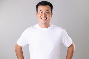 Asian man wearing white t-shirt. Studio shot on grey background