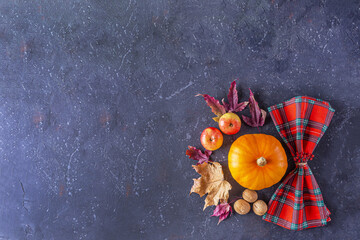Autumn harvest festival and thanksgiving day table setting. Frame from fallen leaves, pumpkin, nuts and checkered napkin. Thanksgiving rustic still life, mock up.