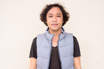 Portrait of Japanese man with curly hair looking at camera