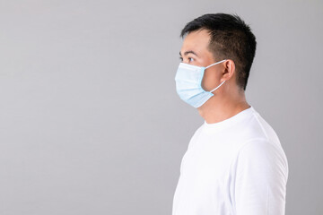 Thai man wearing protective face mask to prevent virus studio shot on grey background
