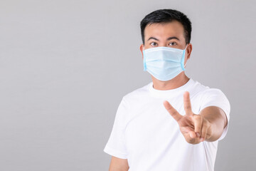 Thai man wearing protective face mask to prevent virus studio shot on grey background