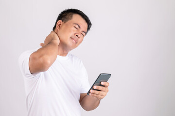 Fototapeta premium Neck pain concept. Man touching his neck because pain or hurt after using too much smartphone. Studio shot isolated on grey