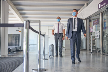Businessman flying away with bodyguard during pandemic