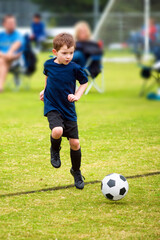 Obraz premium Happy young boy playing organized soccer