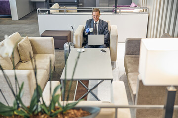 Smiling man with laptop waiting for flight
