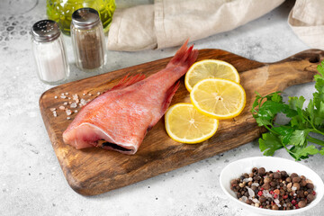 Grouper. Sea bass on a wooden Board on a light gray kitchen table. Raw sea bass closeup	