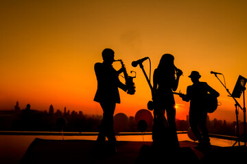 Silhouette twilight scene of trio musician background.