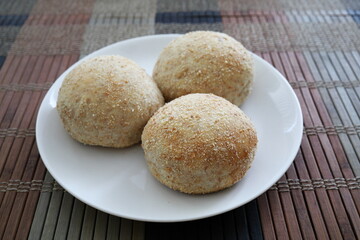 Fresh baked pandesal on white plate.