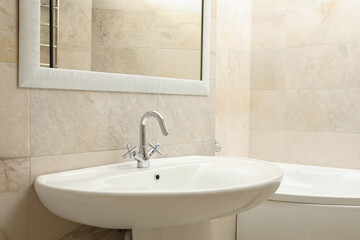 Sink in modern comfortable bathroom in light beige color