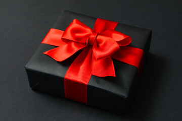 Gift box with red bow on black background