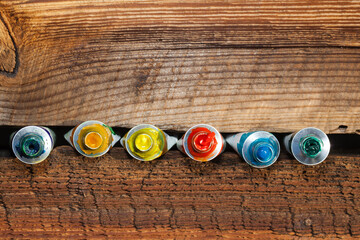 Olejne farby w tubce, na tle starej chropowatej deski. © AP-STUDIO