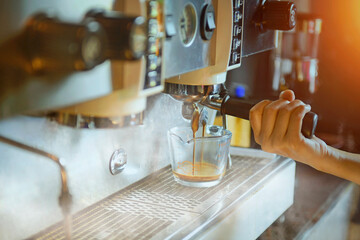 Espresso poruing from coffee machine at cafe,Close-up of espresso pouring from coffee machine....