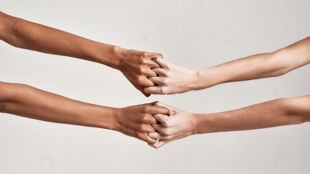 Close up of female hands holding together with fingers crossed isolated over grey background. Diversity, support, friendship concept