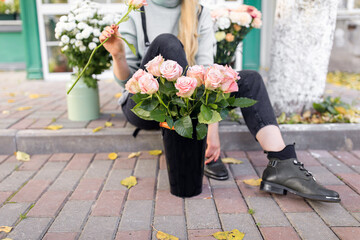 people, business, sale and floristry concept - close up of florist woman holding bunch at flower shop