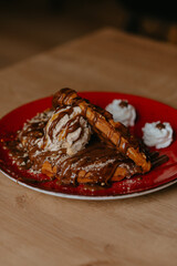 chocolate pancake with bananas, nuts and chocolate sauce. the toning. selective focus. a rolled chocolate pancake is a calorie bomb