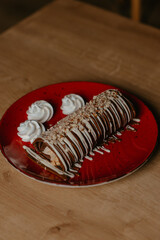 chocolate pancake with bananas, nuts and chocolate sauce. the toning. selective focus. a rolled chocolate pancake is a calorie bomb