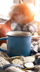 Autumn background with dry leaves, blue cup of coffee. Knitted background, pumpkins, October, November. Autumnal atmosphere. Autumn season.