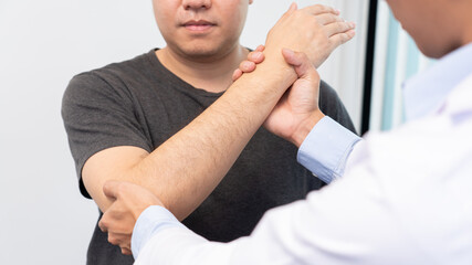 Fototapeta premium Physiotherapist working concept, Doctor and patient suffering or Chiropractor examining from shoulder or elbow pain in clinic medical office.
