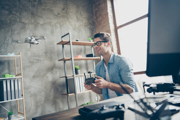 Portrait of his he nice attractive cheerful guy geek specialist expert controlling drone spending time inventing fixing at modern loft industrial home office work place station indoors