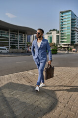 Trendy Indian Arabic businessman walking in city on daily work commute