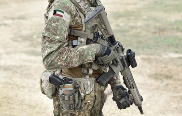 Soldier with assault rifle and flag of Kuwait on military uniform. Collage.