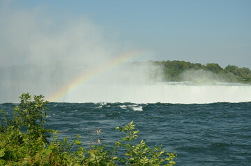 View over the edge of the Canadian Niagara Falls with a rainbow in the haze of the waterfalls