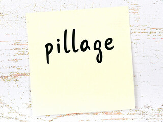 Yellow sheet of paper with word pillage. Reminder concept
