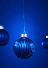 Vertically striped blue Christmas balls hanging against royal blue background.