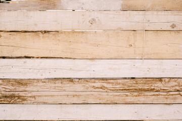 Wooden fence made of boards without paint with cracks and crevices.