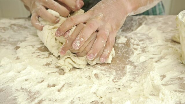 Male and female hands knead the dough together. Close-up. Mutual relationship.
