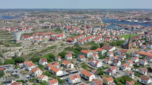 Smogen from above. Aerial drone shot of Sweden west coast most popular tourist town. Coastal homes in Swedish coastline. Luxurious expensive residential homes. Kungshamn and church view sunny summer
