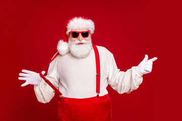 Fototapeta na wymiar Portrait of his he nice handsome cheerful cheery bearded Santa demonstrating copy space novelty advice pulling suspender having fun isolated bright vivid shine vibrant red color background