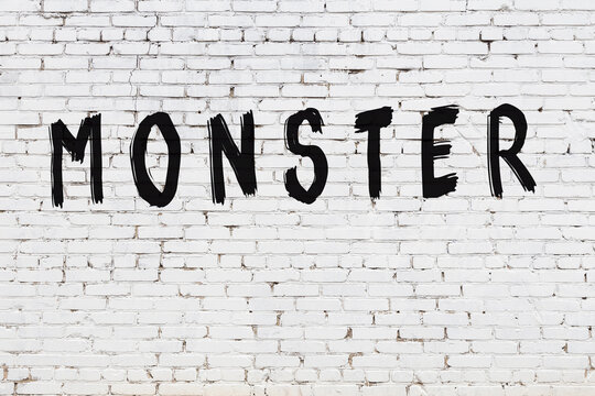 Inscription monster painted on white brick wall